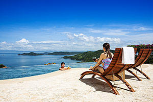 Family in pool overlooking scenic view, Costa Rica