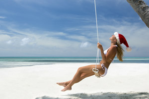 Woman in Santa hat on Caribbean beach