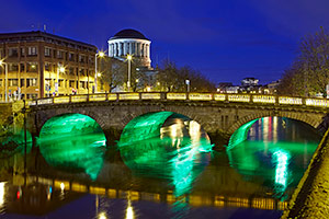 The 'Four courts' illuminated by bridge in River Liffey at night